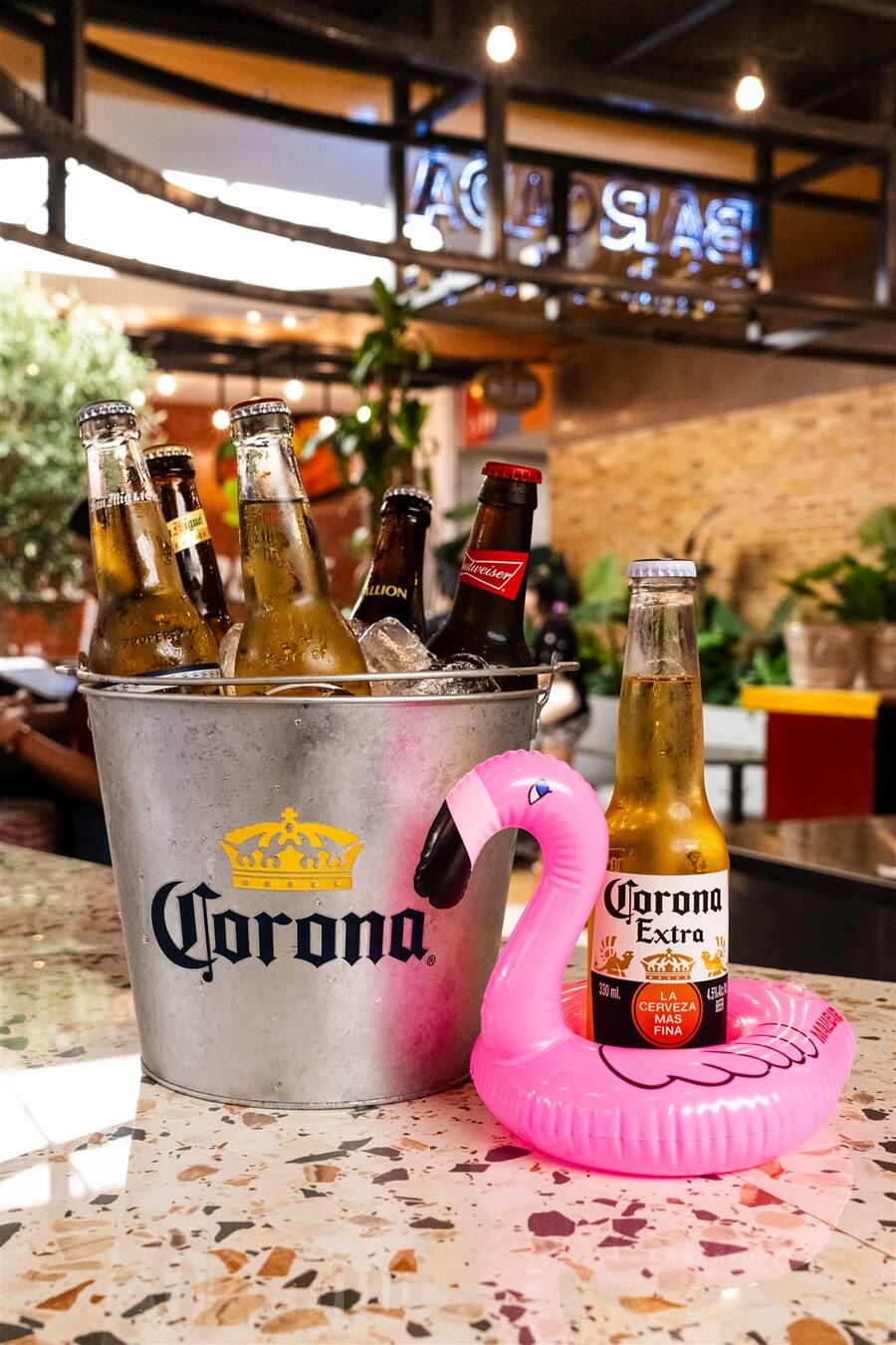 A Corona bucket and a flamingo floatie at Barcada
